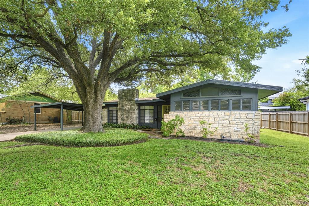 Original one-story mid-century home in Allandale with a limestone facade and mature oak tree