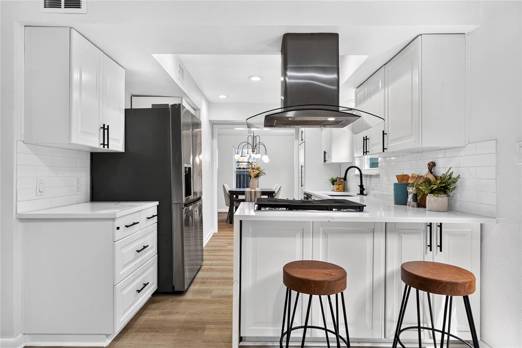 Remodeled kitchen in an Allandale home with white cabinetry, subway tile, and stainless steel appliances