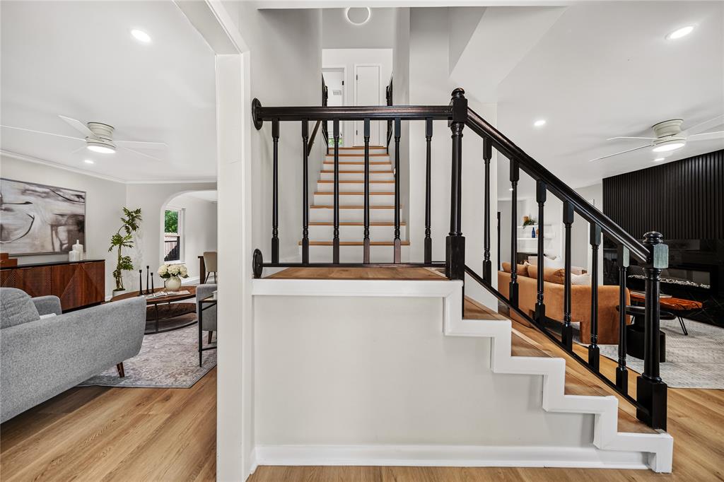 Remodeled interior staircase and living area in an Allandale home with wood flooring and black railings